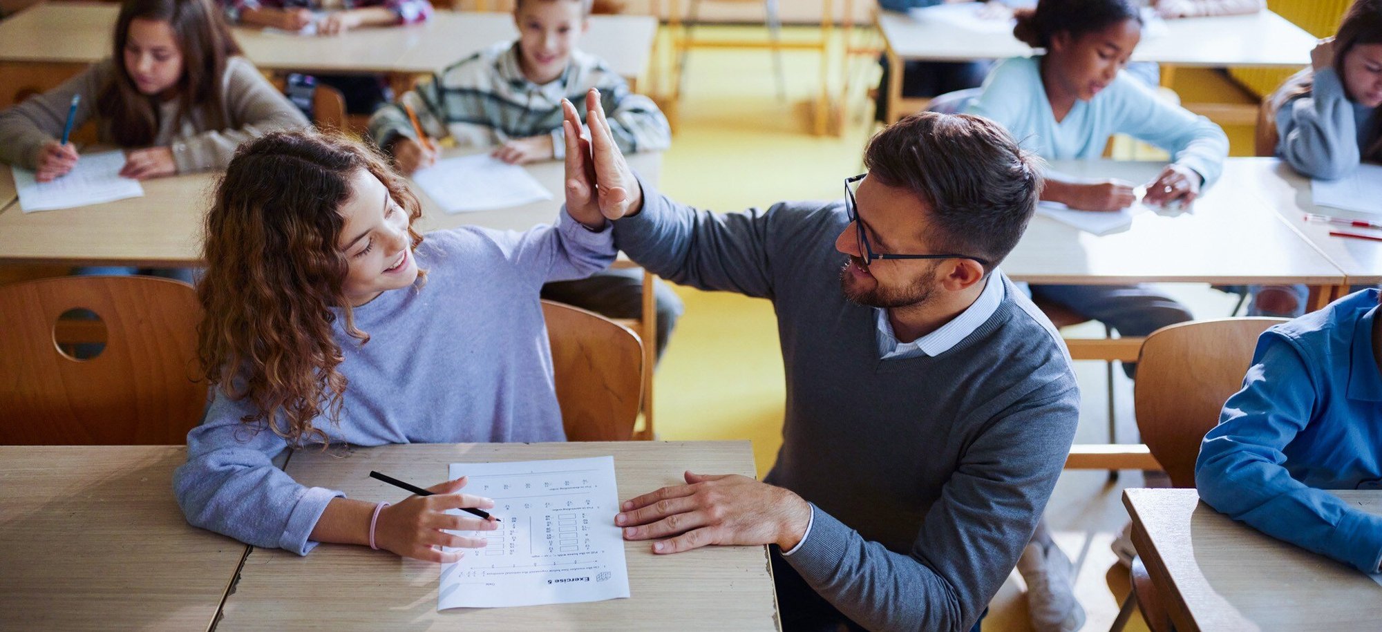 teacher celebrating a student's good test score with a high five