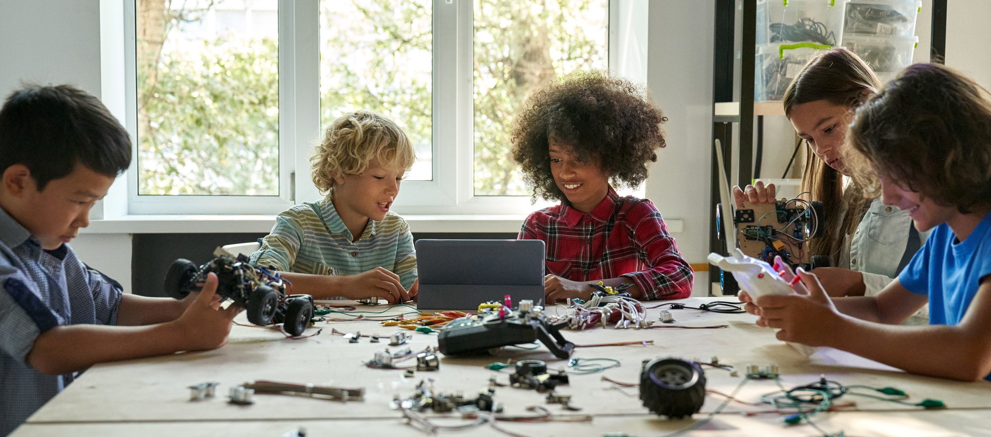 children around a table building robots