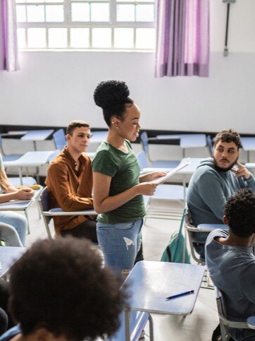 Student standing and reading poetry in class