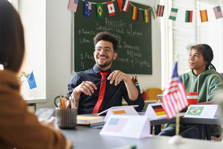 Smiling social studies teacher with students in a civics classroom